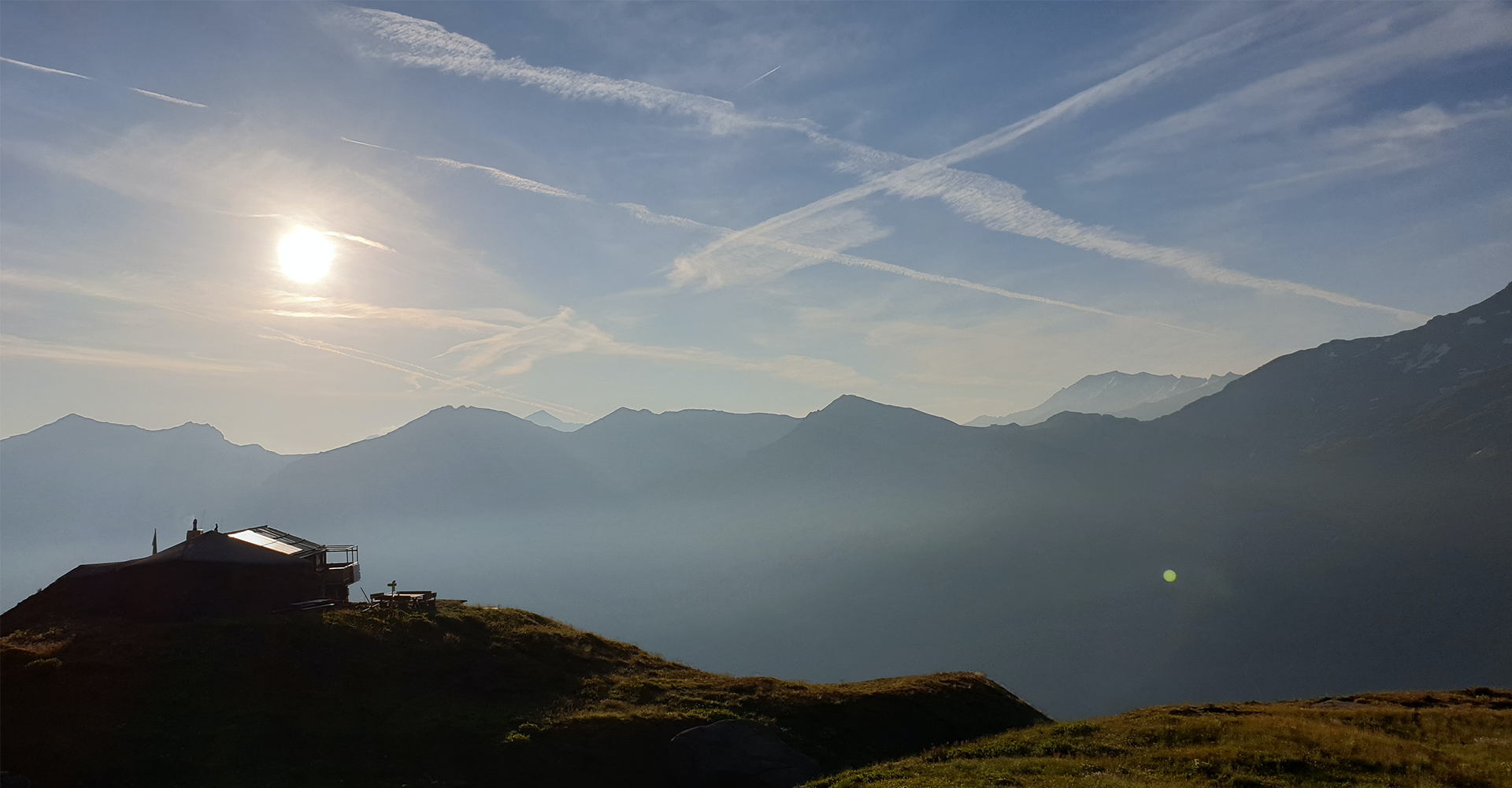 Landschaft mit Bergen und Hütte