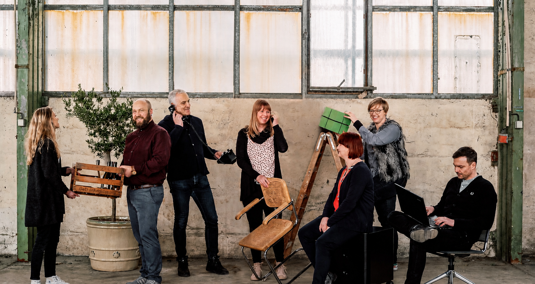 Team in der Kranhalle in legerer Kleidung